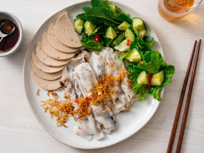 Vietnamese banh cuon steamed rice rolls with pork mushroom filling, fried shallots, herbs, chả lụa, and nuoc cham