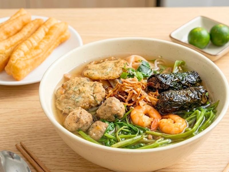 Hai Phong banh da cua with red noodles, freshwater crab, vegetables, and savory broth