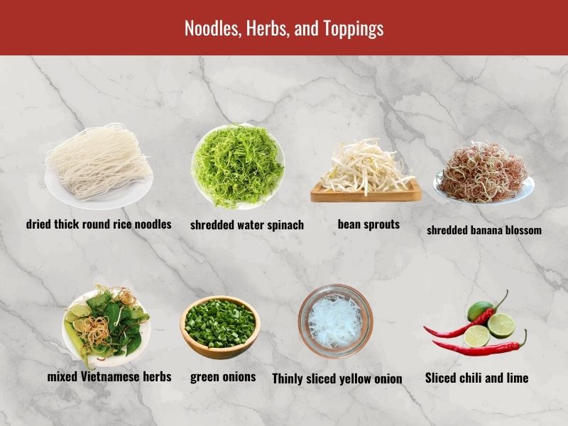 Bun bo Hue serving ingredients including thick rice noodles, herbs, bean sprouts, banana blossom, lime, chili, and green onion
