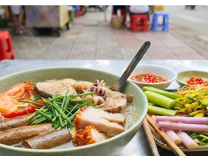 Bun mam with fermented fish broth, seafood, pork, thick rice noodles, and Mekong Delta vegetables