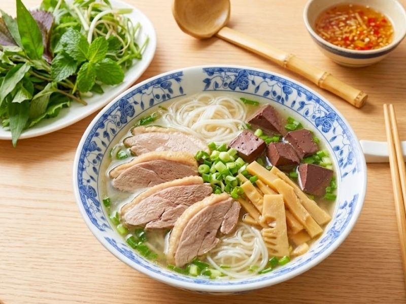 Bun mang vit with duck meat, bamboo shoots, rice vermicelli, herbs, and ginger fish sauce