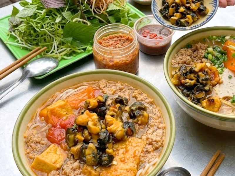 Vietnamese bun rieu cua with freshwater crab curds, tomato broth, rice noodles, tofu, and herbs