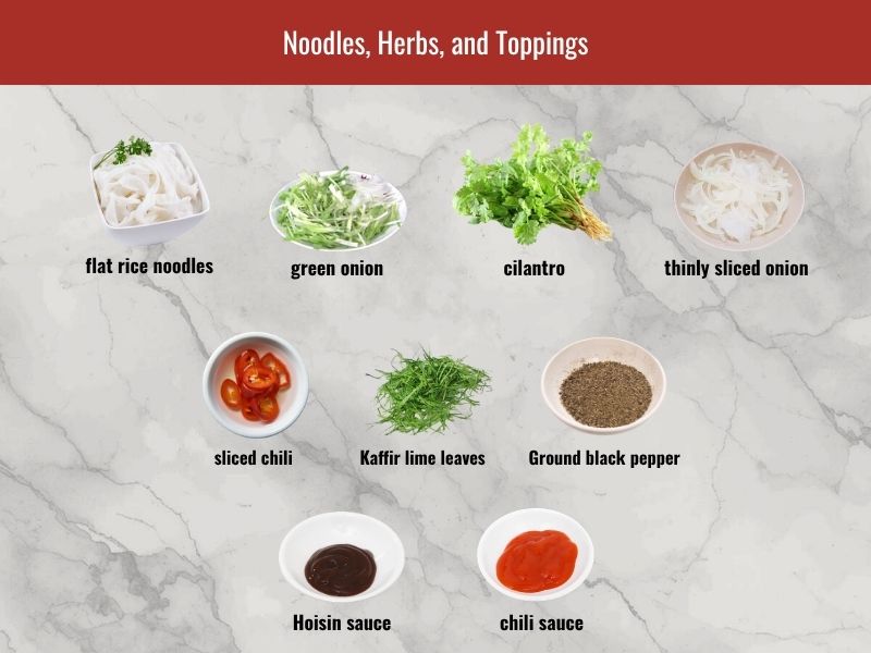 Chicken pho serving ingredients including flat rice noodles, green onion, herbs, lime, onion, hoisin sauce, and chili sauce