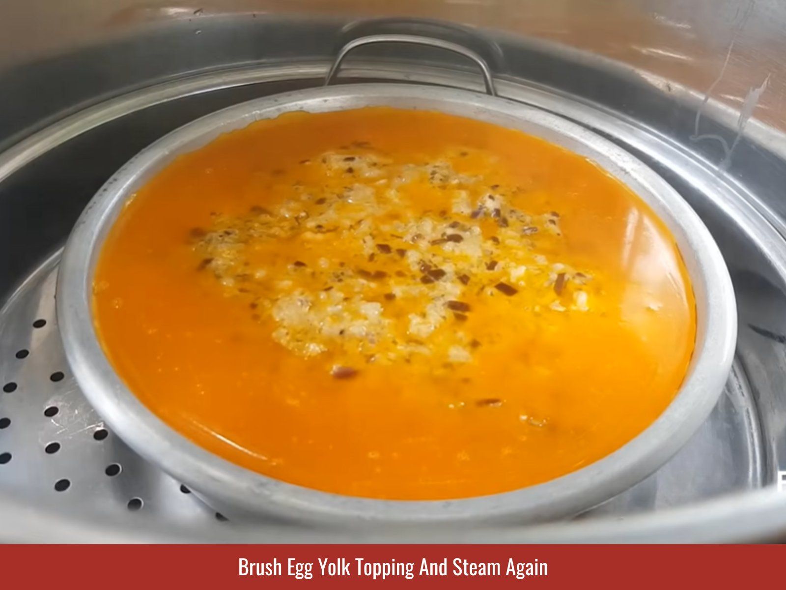Brushing yolk topping onto steamed egg meatloaf