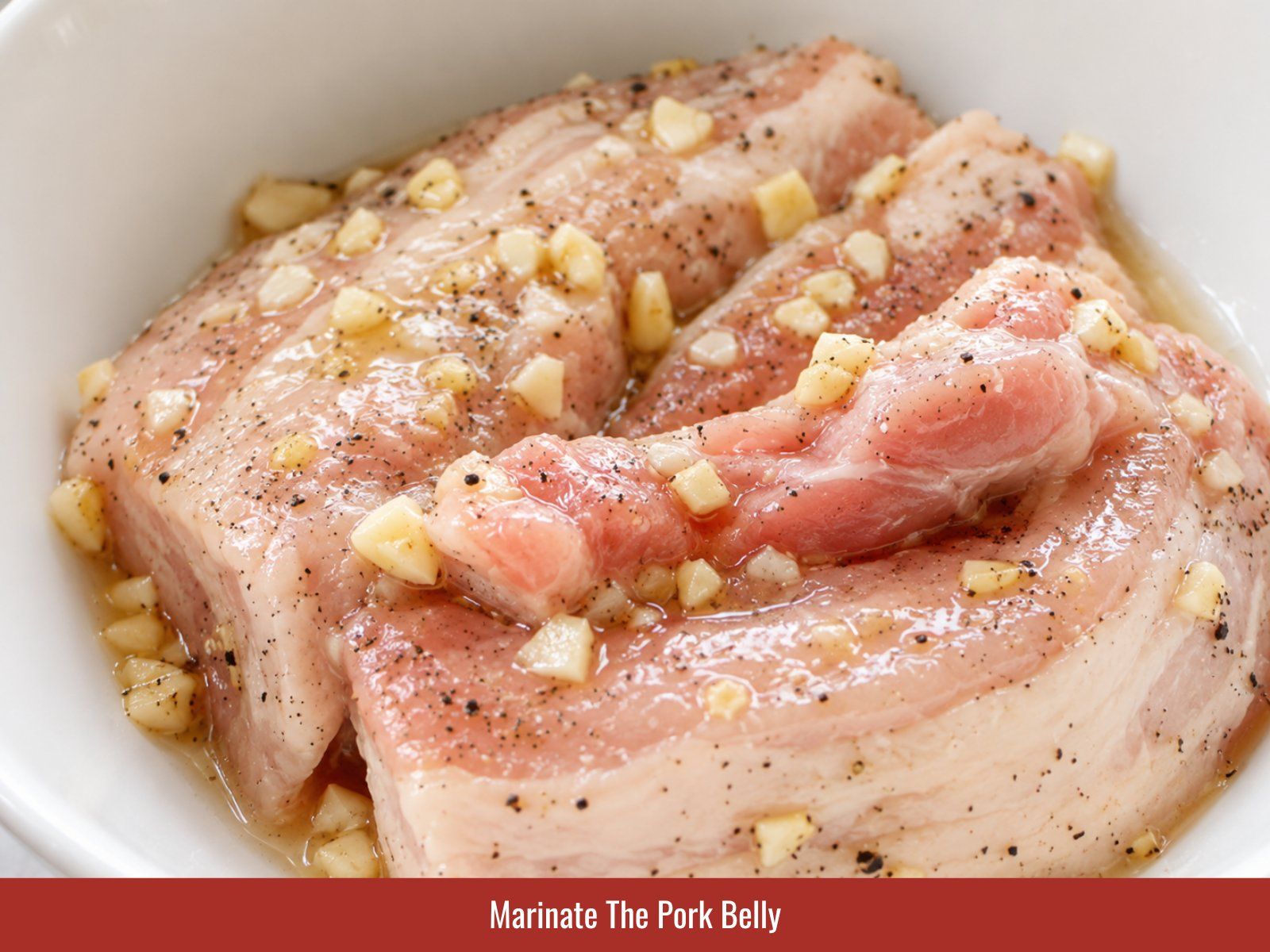 Rubbing garlic seasoning into skinless pork belly