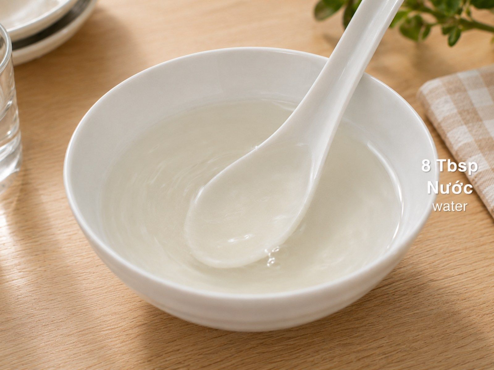 Sugar dissolving in water inside a bowl, stirred until the liquid turns clear
