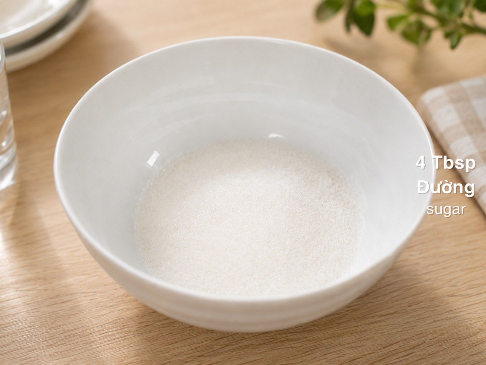 Four tablespoons of sugar measured into a small mixing bowl as the first step of making nuoc cham