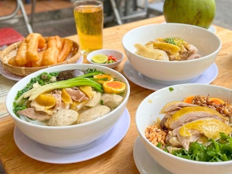 Vietnamese pho ga with poached chicken, flat rice noodles, clear broth, ginger, onion, and fresh herbs