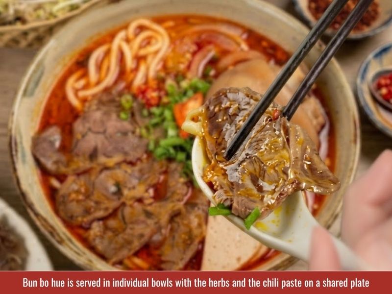 Serving bun bo Hue with fresh herbs, bean sprouts, lime, chili, banana blossom, and spicy broth