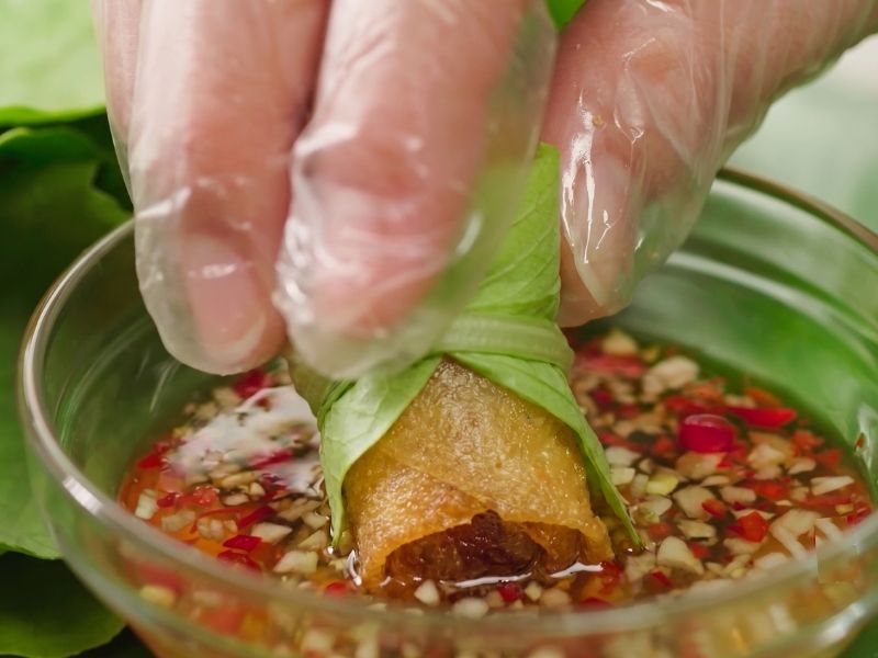 Serving cha gio with lettuce, fresh herbs, pickled vegetables, and Vietnamese dipping sauce