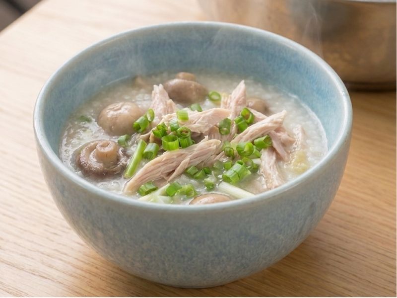 Serving chao ga with shredded chicken, herbs, fried shallots, black pepper, and Vietnamese table seasonings