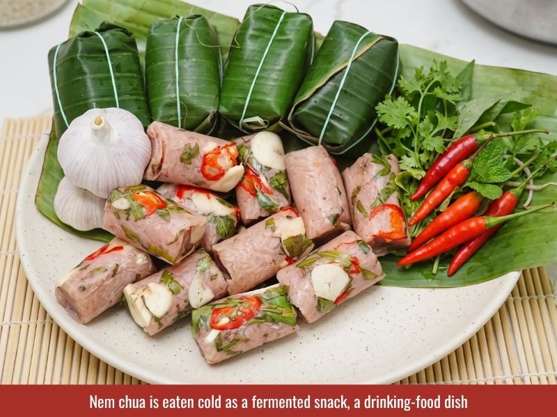 Serving nem chua with sliced garlic, chili, Vietnamese coriander, and traditional accompaniments