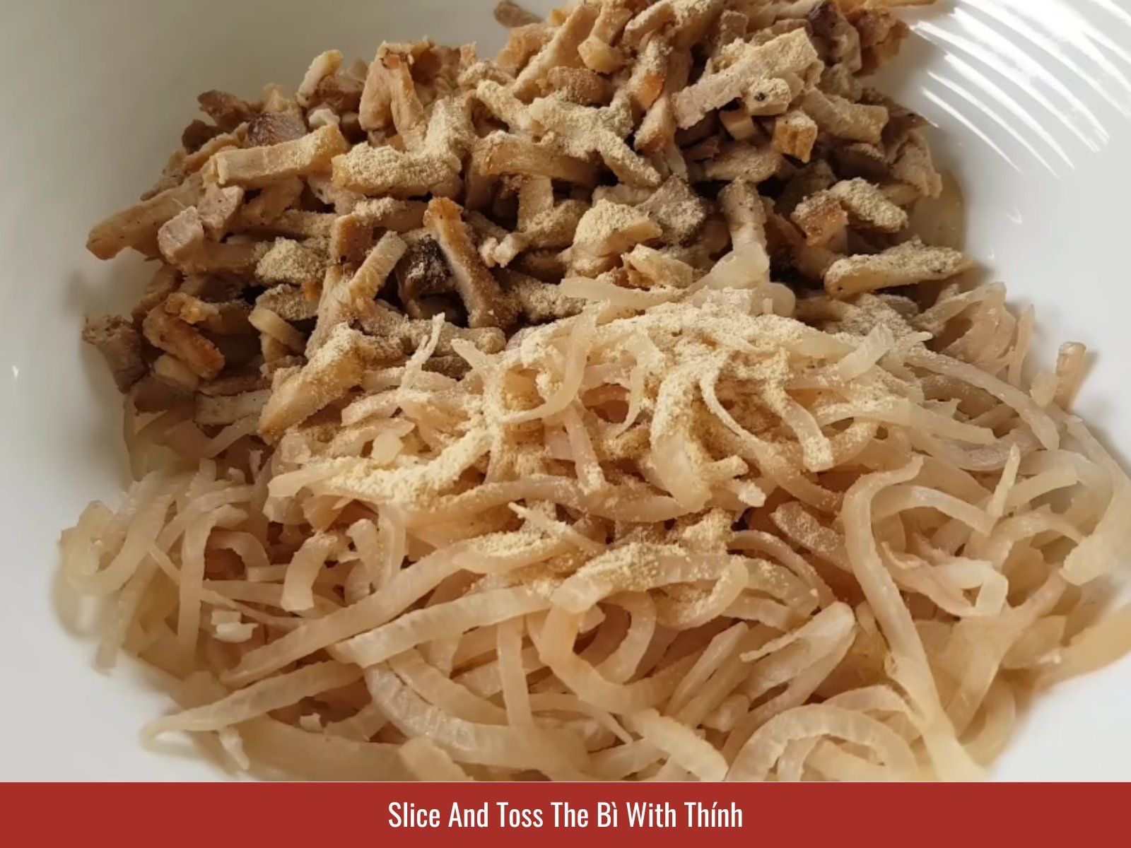 Tossing shredded pork skin with toasted thinh
