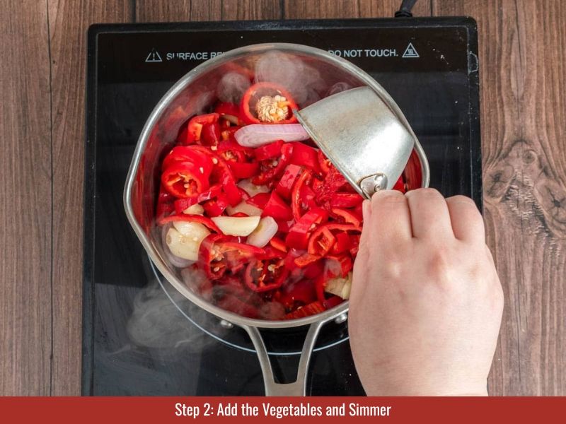 Simmer peppers, vegetables, vinegar, and salt for 15-20 minutes until soft and deeply colored.