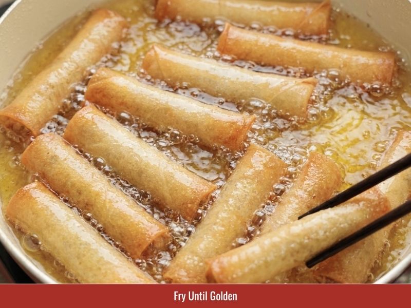 Deep frying cha gio until the wrappers become golden and crispy