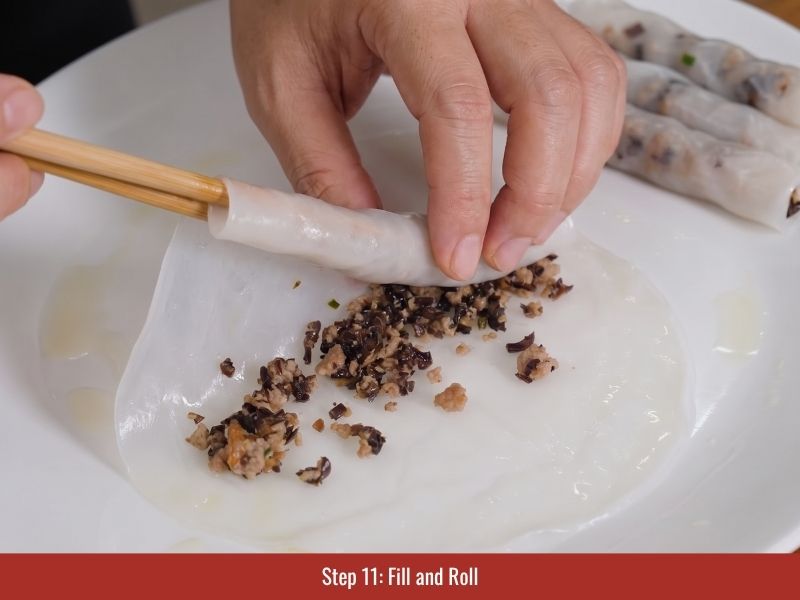 Adding pork mushroom filling and rolling soft steamed rice sheets into Vietnamese banh cuon rolls