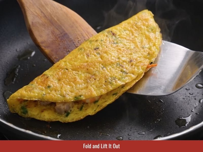 Folding the crispy Vietnamese pancake and removing it carefully from the skillet