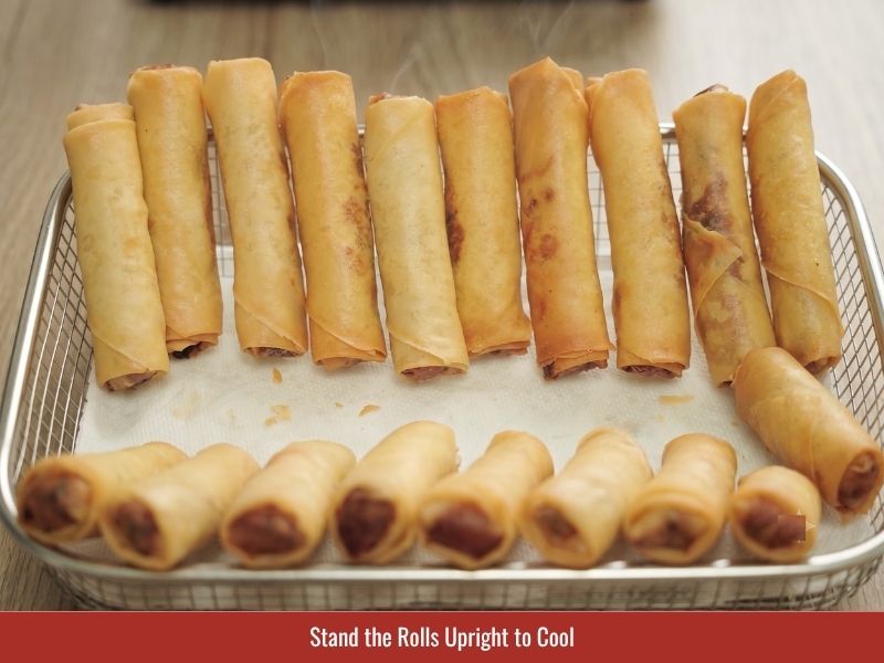 Cooling fried cha gio upright to release steam and maintain crispy wrappers
