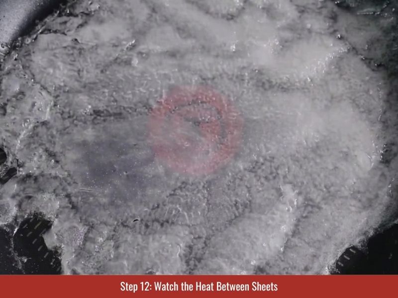 Adjusting skillet heat between banh cuon sheets to maintain soft flexible texture
