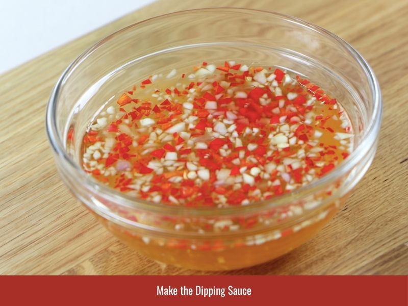 Preparing Vietnamese nuoc cham with fish sauce, sugar, lime, garlic, and chili