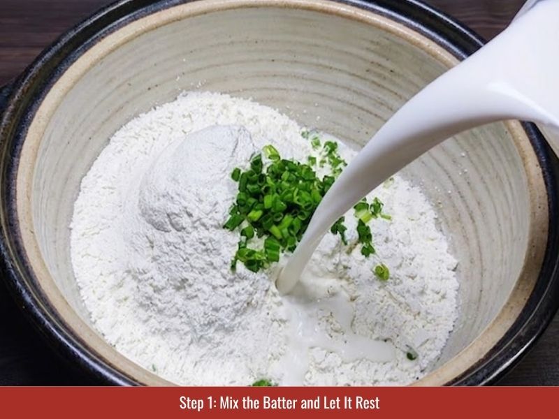 Mixing rice flour batter with coconut milk, seasoning, and green onion before resting for banh khot