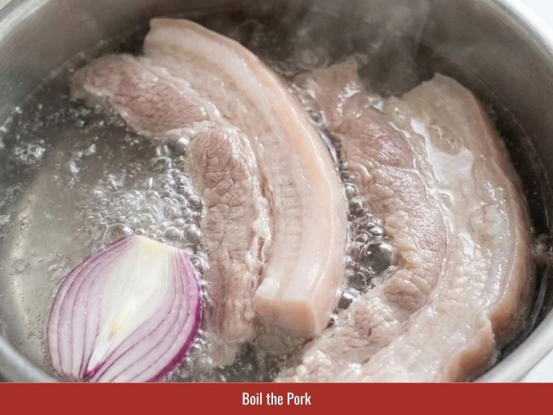 Cooking pork belly for Vietnamese banh xeo filling until tender before slicing