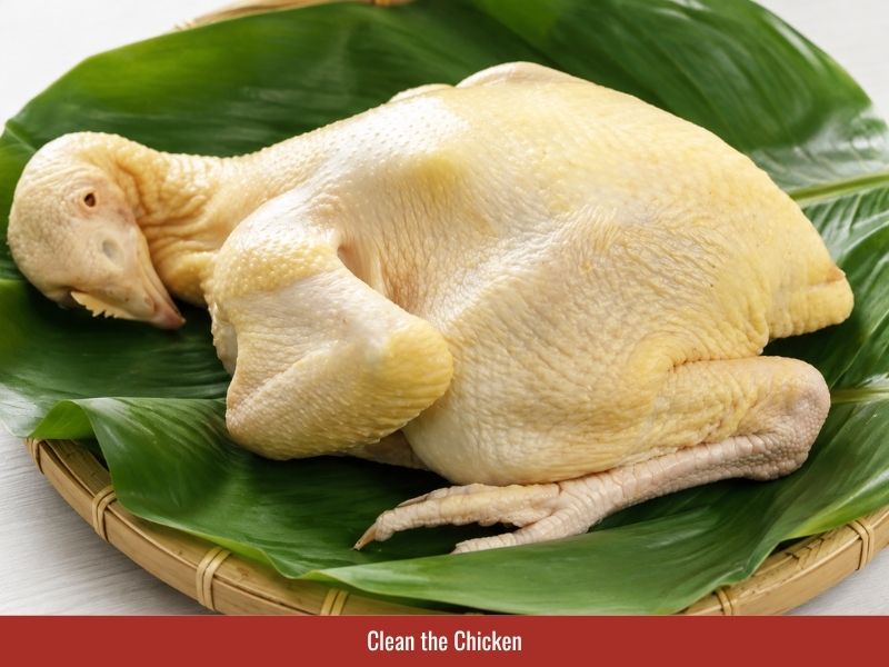 Cleaning a whole chicken with salt and lime before making Vietnamese chicken rice porridge