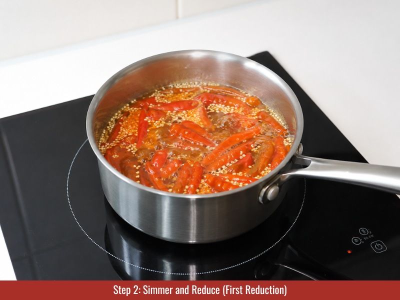 Simmer cayenne peppers with vinegar