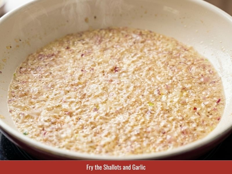 Frying shallots and garlic to create aromatic seasoning for cha gio filling
