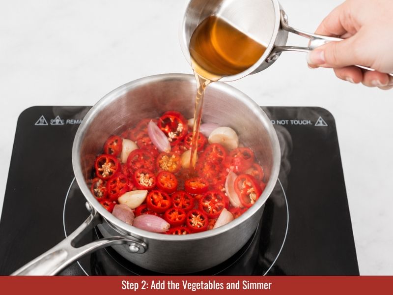 Peppers and vegetables simmering in seasoned vinegar