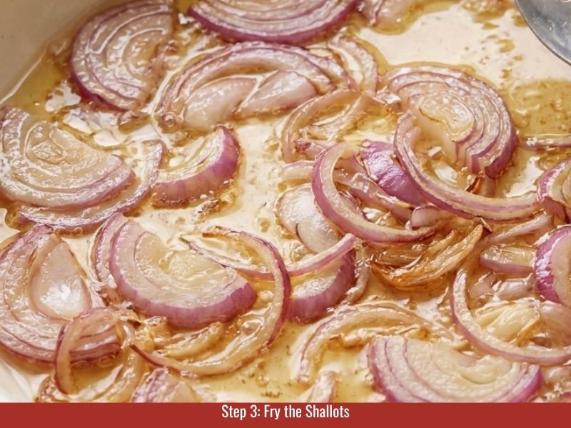 Frying sliced shallots slowly until golden and crispy for Vietnamese steamed rice rolls