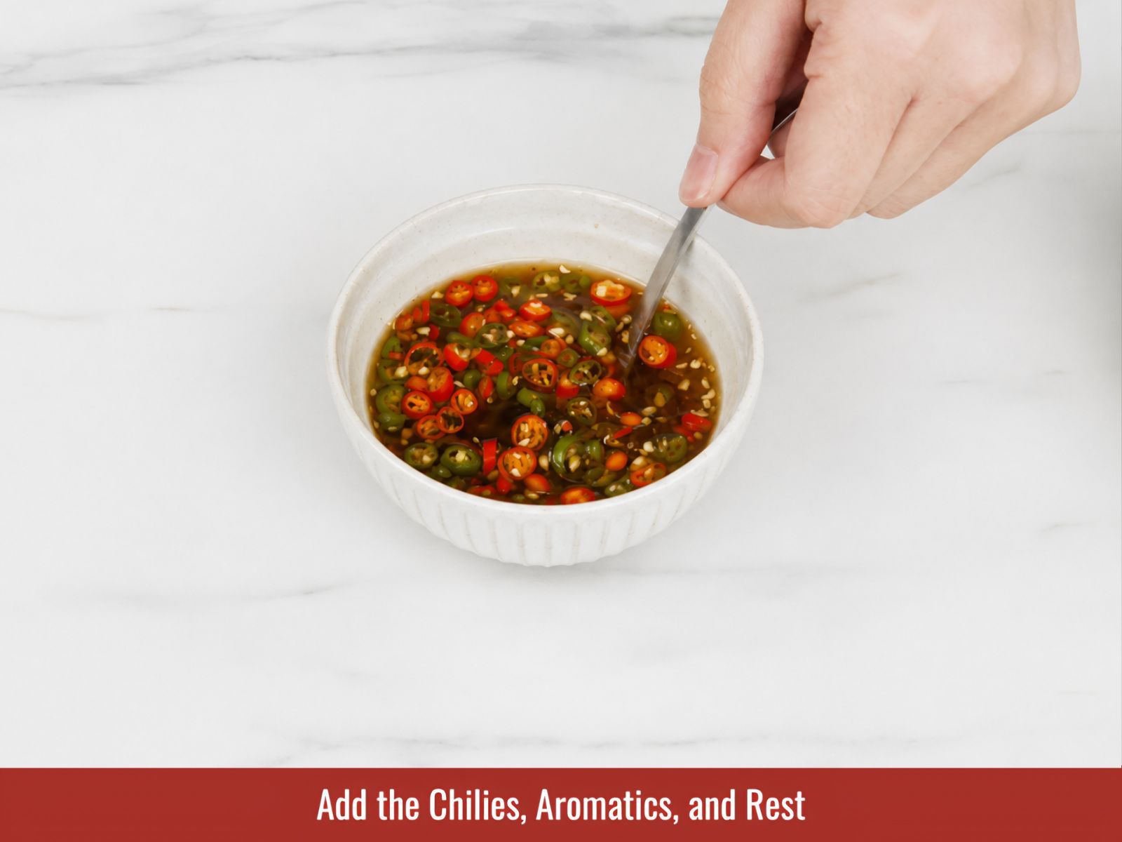Adding chopped chilies garlic and shallots to fish sauce