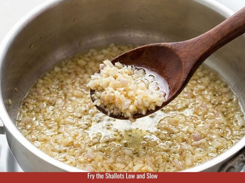 Slowly frying shallots until aromatic and crisp to make traditional banh uot topping