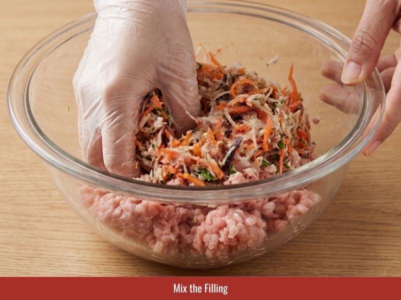 Combining pork shrimp filling with vegetables and noodles for Vietnamese spring rolls