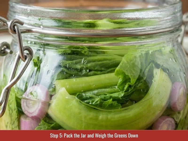 Packing mustard greens, scallions, and shallots into brine while keeping vegetables fully submerged