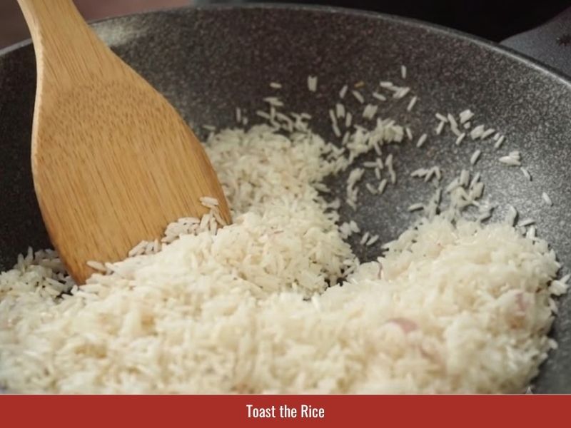 Toasting rinsed rice with chicken fat and shallots to create lighter chao ga texture