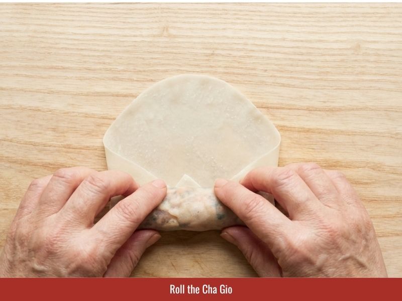 Rolling Vietnamese fried spring rolls with filling and sealing the wrapper edges