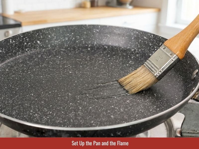 Preparing a nonstick skillet with low heat for cooking thin banh uot rice sheets
