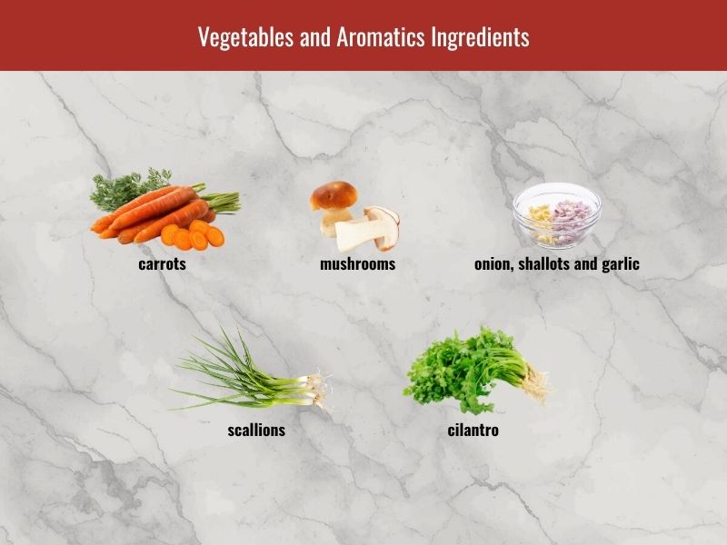 Sup nui vegetables and aromatics including carrots, mushrooms, onion, shallots, garlic, scallions, and cilantro